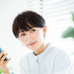 スマホ片手に何か考えている女性150×150